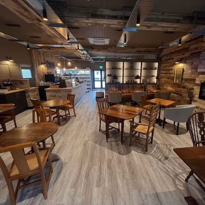 Toast cafe with tables and chairs with a tv on the wall